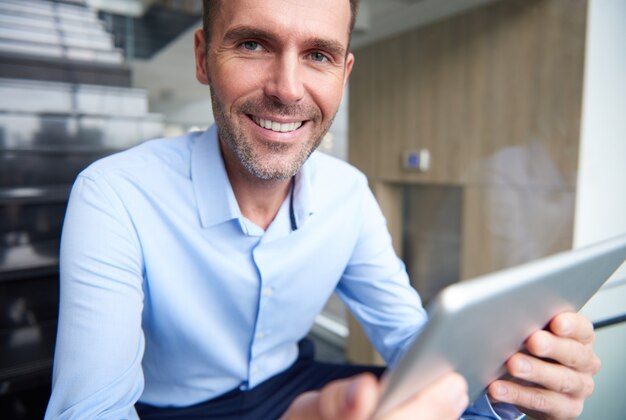 Homme parcourant la tablette numérique au bureau