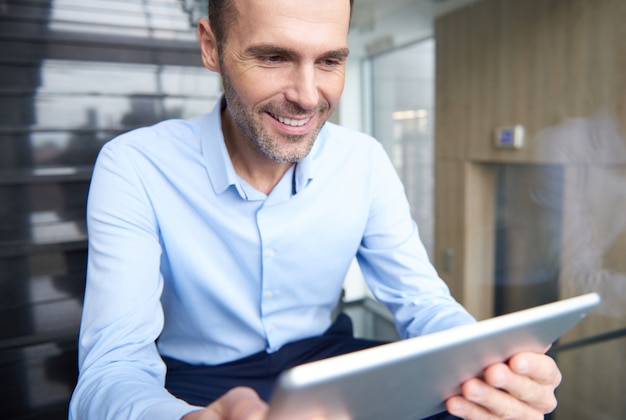 Homme parcourant la tablette numérique au bureau