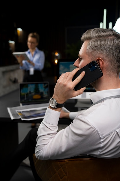 Photo gratuite homme parlant au téléphone au travail