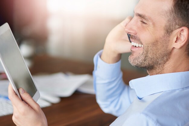 Homme parlant au téléphone et navigation tablette numérique