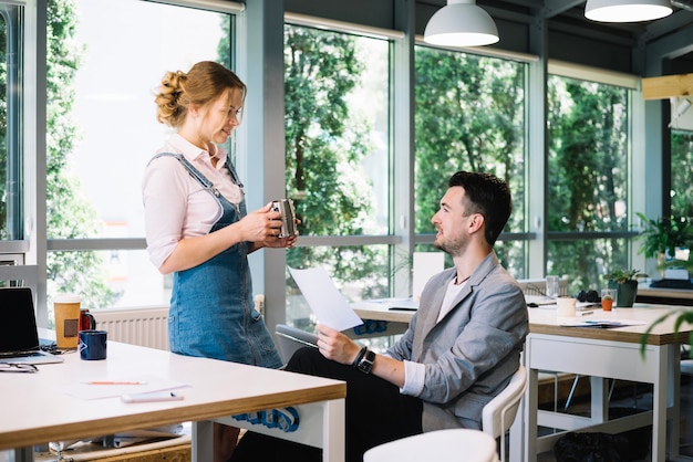 Homme parlant avec une femme à propos de documents