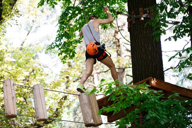 Photo gratuite l'homme passe sur les blocs de bois suspendus dans l'air