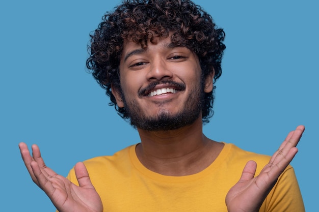 Homme avec les paumes vers le haut souriant à la caméra