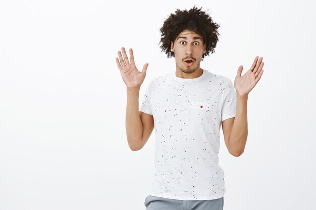 Homme à la peau sombre confus levant les mains et à la recherche d'une embuscade