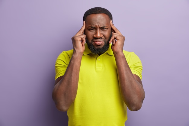 L'homme à la peau sombre touche les tempes et a la migraine isolée