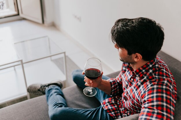 Homme pensif avec du vin à la maison