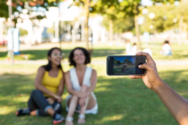 Homme photographiant des amies dans le parc