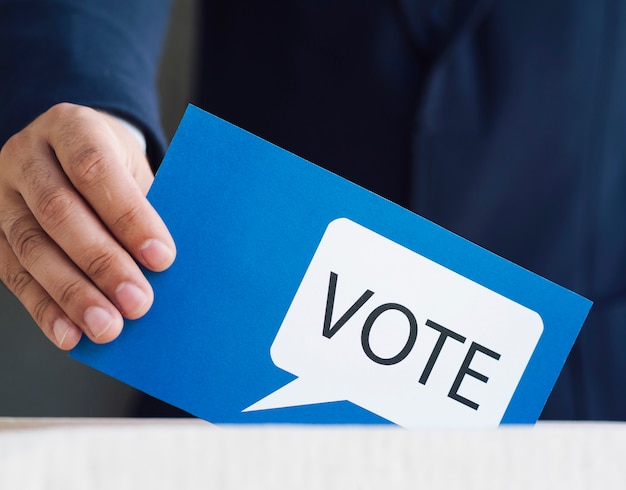 Homme plaçant dans une boîte son bulletin de vote