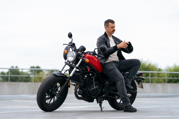 Un homme en plein air avec une moto.