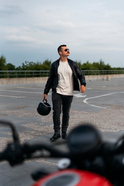Un homme en plein air avec une moto.