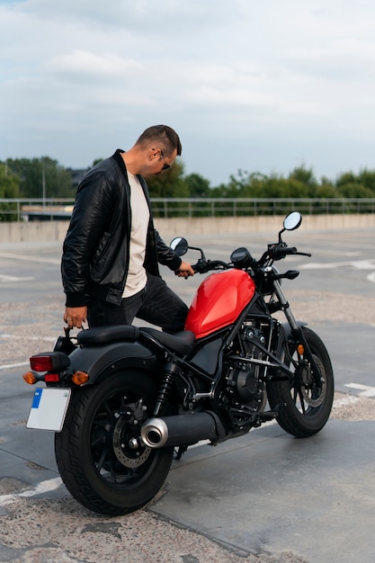 Un homme en plein air avec une moto.