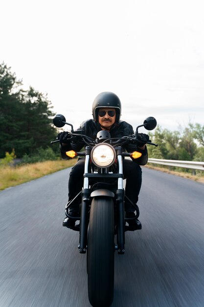 Un homme en plein air avec une moto.