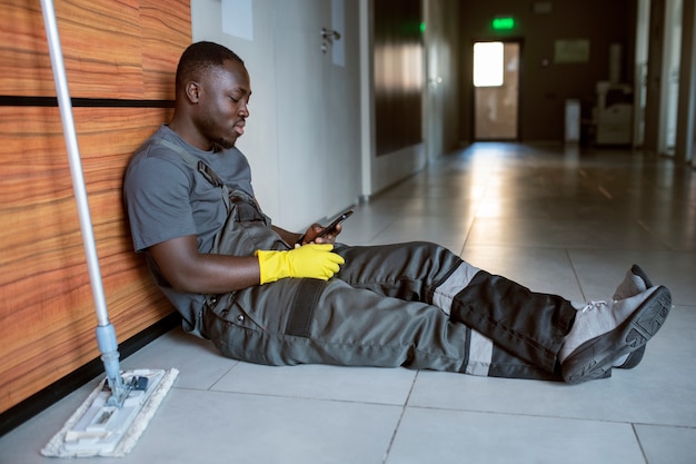 Homme plein coup assis avec smartphone