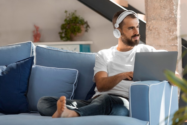 Homme plein coup sur canapé avec ordinateur portable