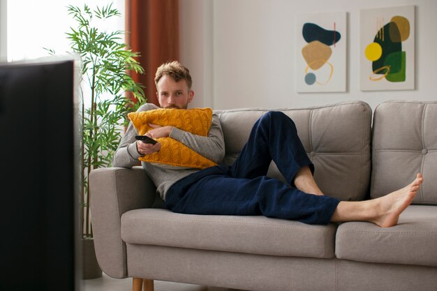 Homme plein coup sur le canapé en regardant la télévision