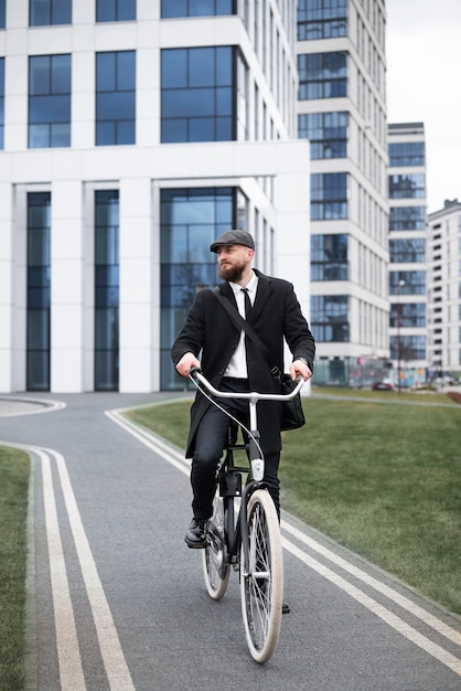 Photo gratuite homme plein coup en costume faisant du vélo au travail