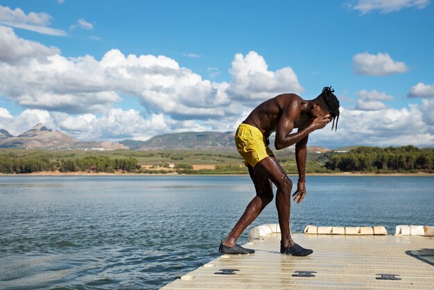 Homme plein coup debout au bord du lac