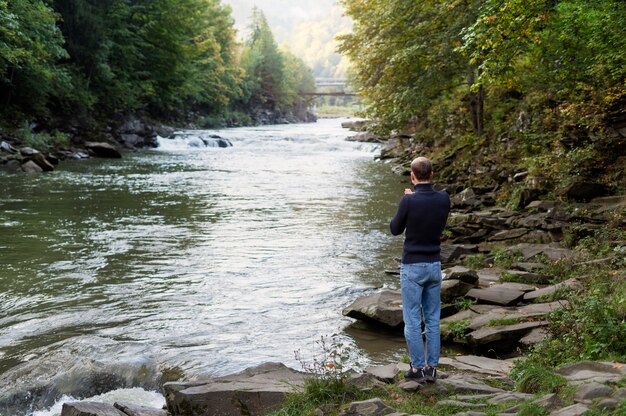 Homme plein coup debout au bord de la rivière