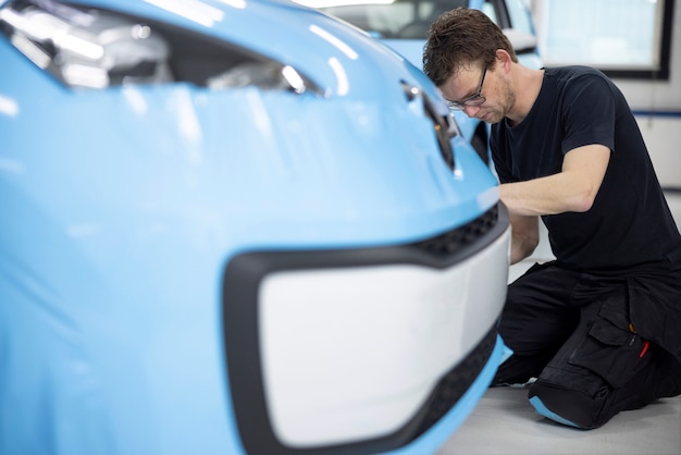 Homme plein coup emballant une voiture au travail