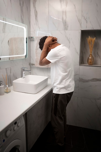 Homme plein coup étant triste dans la salle de bain