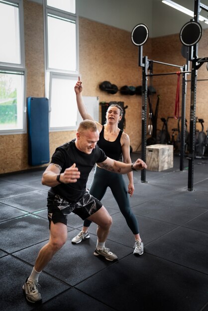 Homme plein coup faisant des burpees avec un entraîneur