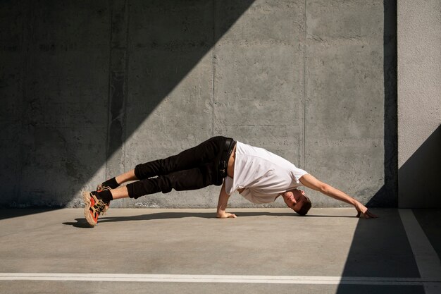 Homme plein coup faisant de l'entraînement de parkour à l'extérieur