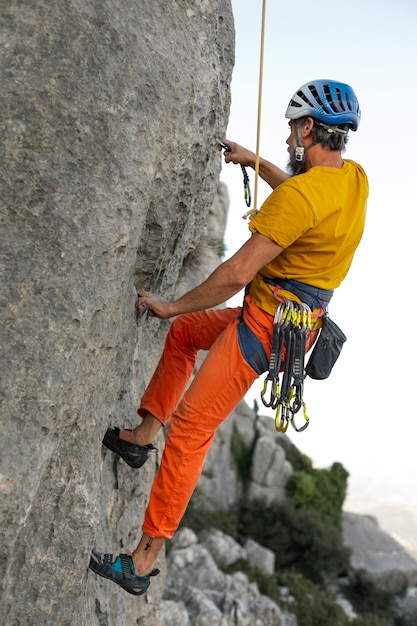 Photo gratuite homme plein coup grimpant dans les montagnes