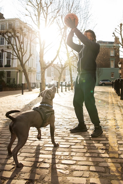 Photo gratuite homme plein coup jouant avec un chien à l'extérieur