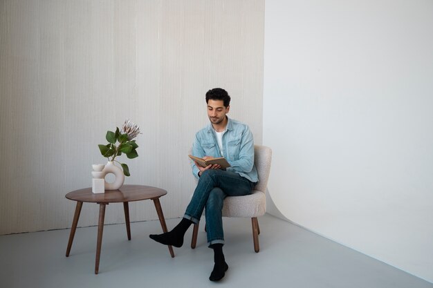 Homme plein coup lisant sur une chaise