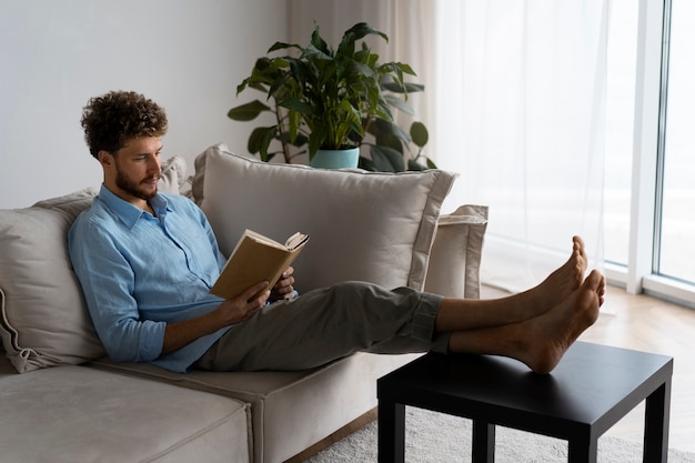 Photo gratuite homme plein coup lisant à la maison