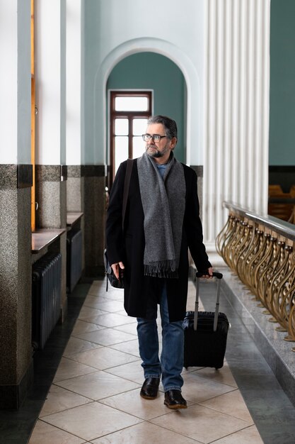 Homme plein coup marchant avec des bagages