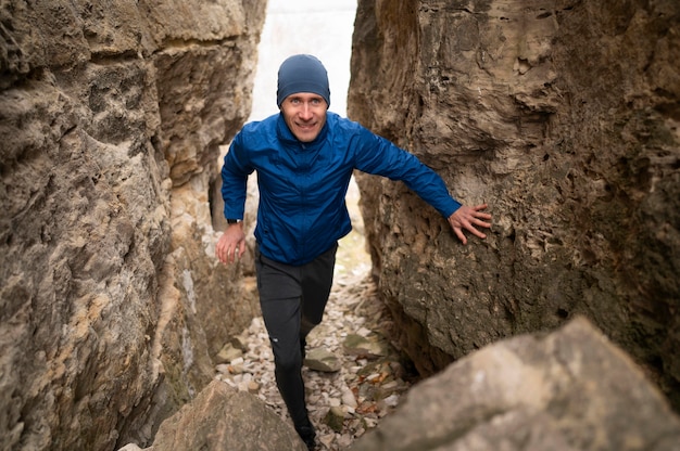 Homme plein coup marchant à travers les rochers