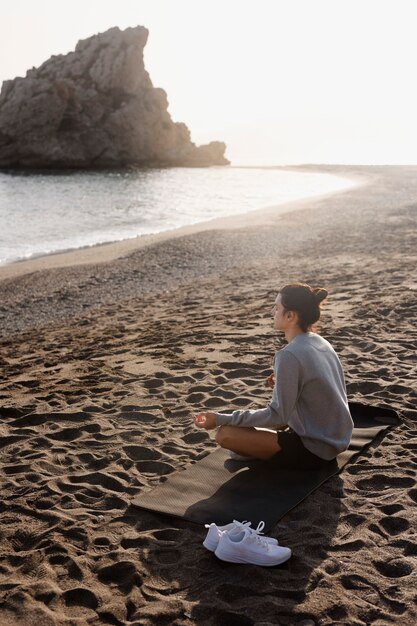 Homme plein coup méditant à la plage