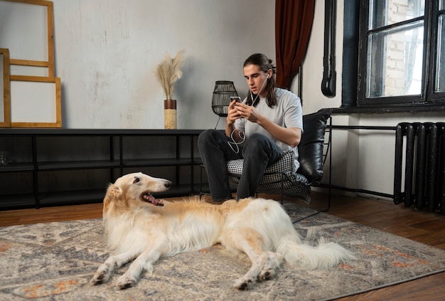 Photo gratuite homme plein coup avec mignon chien lévrier