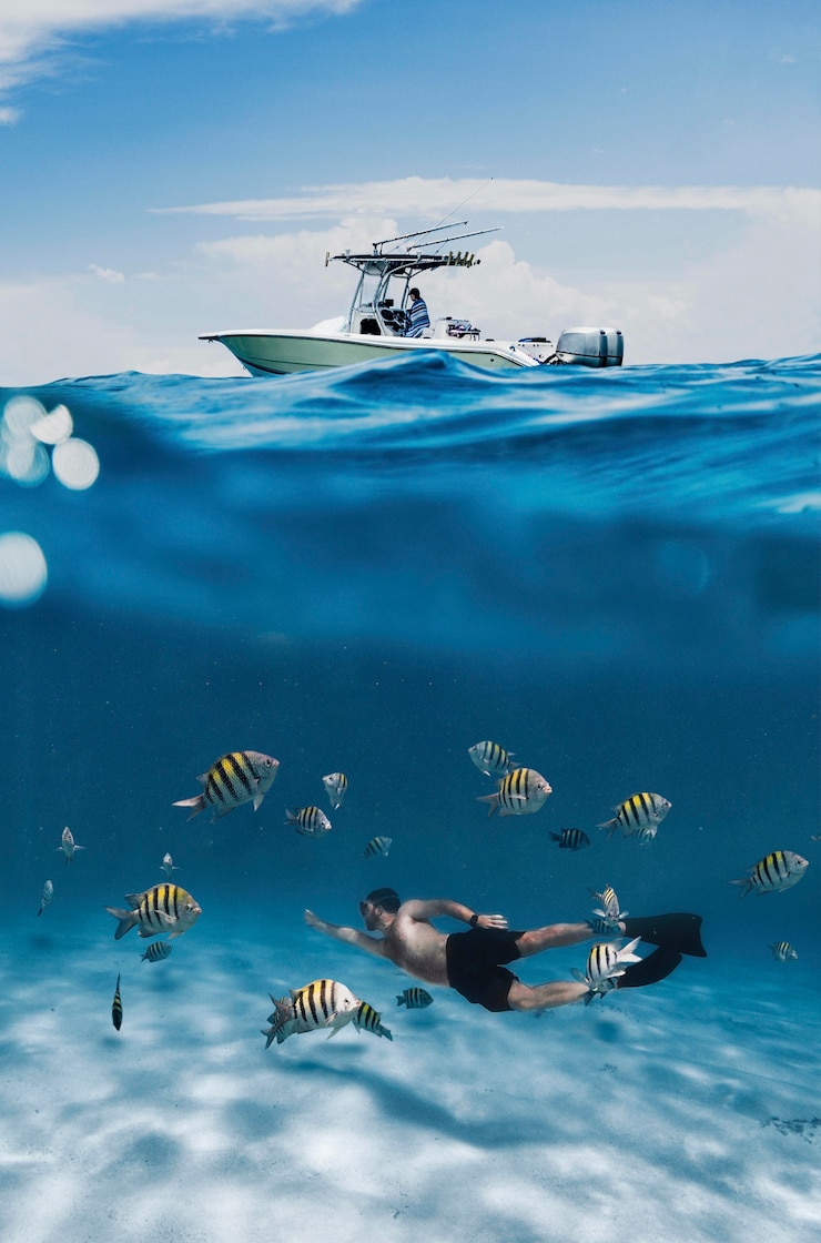 Photo gratuit homme plein coup nageant avec des poissons