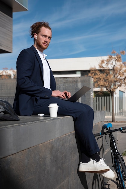 Homme plein coup avec ordinateur portable et écouteurs