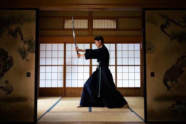 Homme plein coup pratiquant avec l'épée à l'intérieur