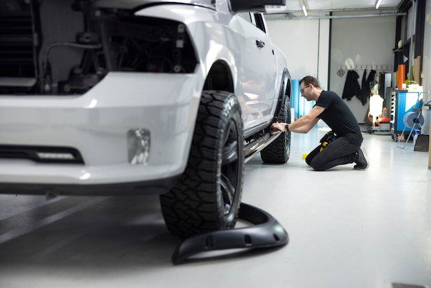 Photo gratuite homme plein coup prenant soin de la voiture