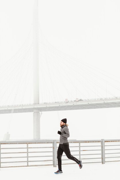 Homme plein coup qui court en hiver