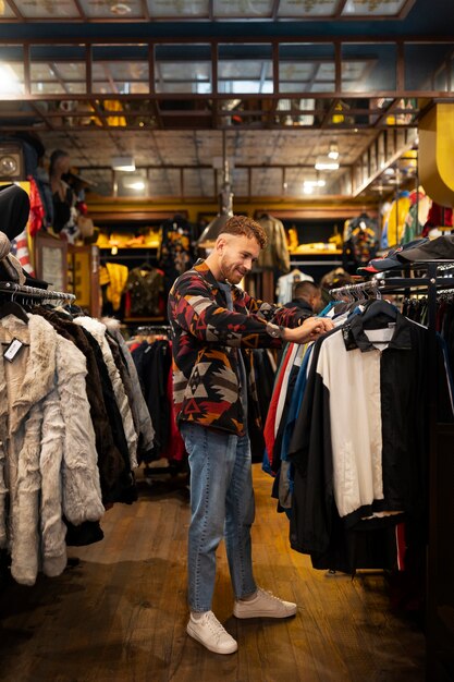 Homme plein coup regardant des vêtements