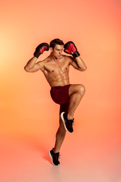 Photo gratuite homme plein coup s'entraînant avec des gants de boxe