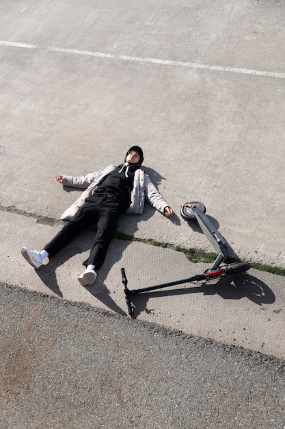 Photo gratuite homme plein coup et scooter électrique posé sur le sol