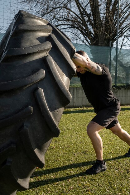 Homme en pleine forme faisant de l'exercice avec une roue