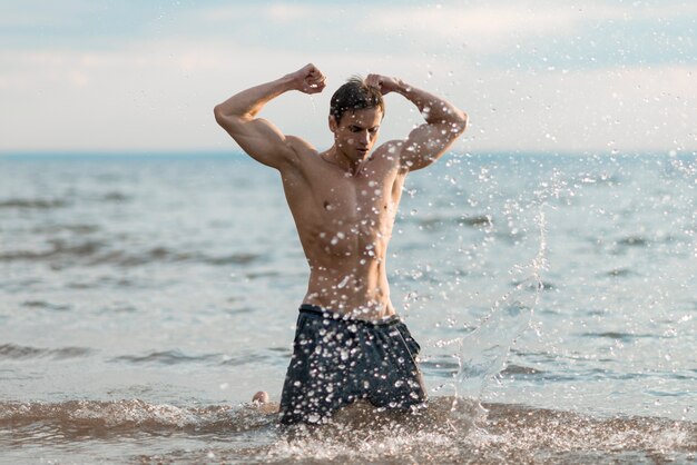 Homme pliant ses biceps dans l&#39;eau