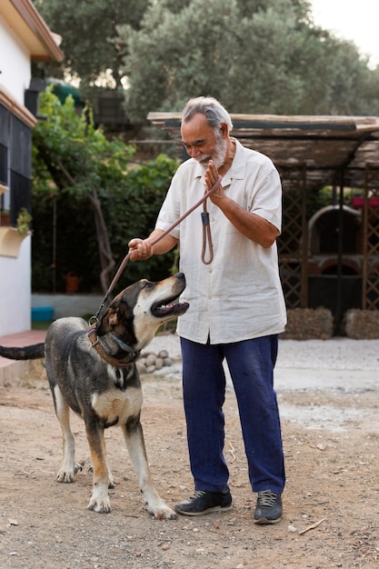 Homme plus âgé dans sa maison de campagne avec son chien