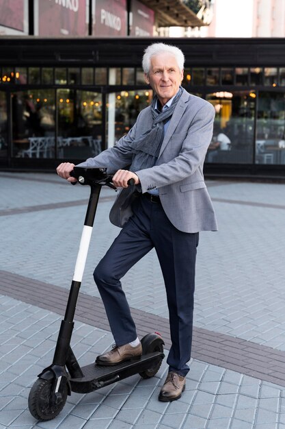 Homme plus âgé dans la ville avec scooter électrique