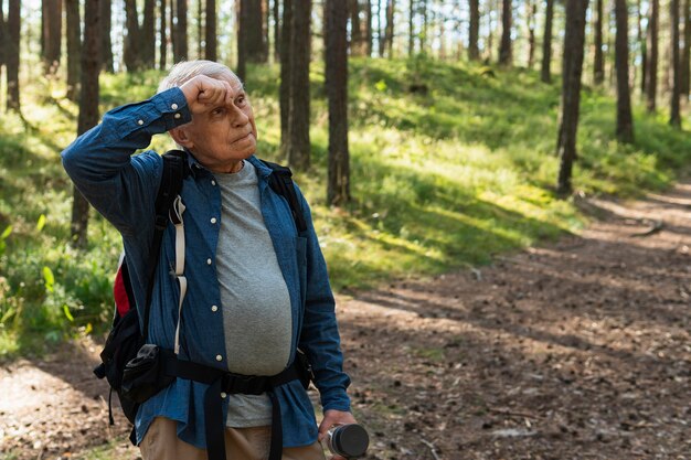 Homme plus âgé prenant une pause de voyager à l'extérieur avec sac à dos