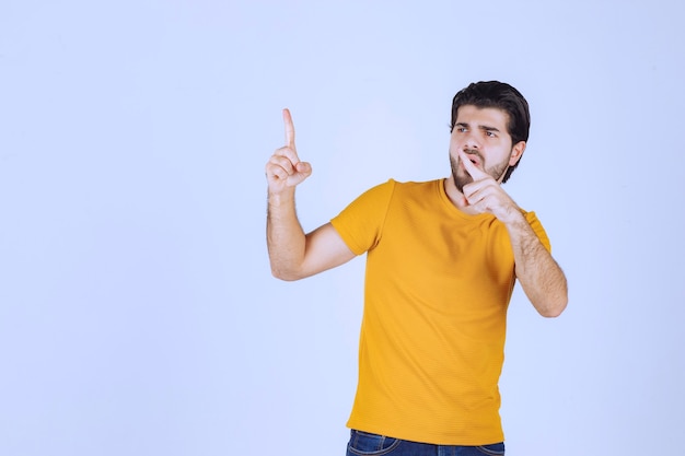 Homme pointant vers le haut et démontrant quelque chose.