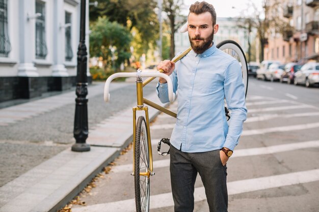 Homme portant une bicyclette