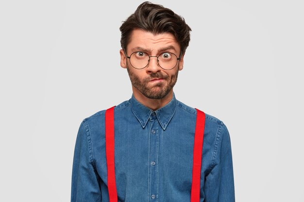 Homme portant une chemise en jean et des bretelles rouges